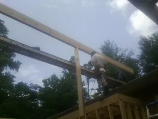 Carpenter setting a ridge beam over a new addition frame — Ice Dam Removal by Roofing Brothers in Farmington