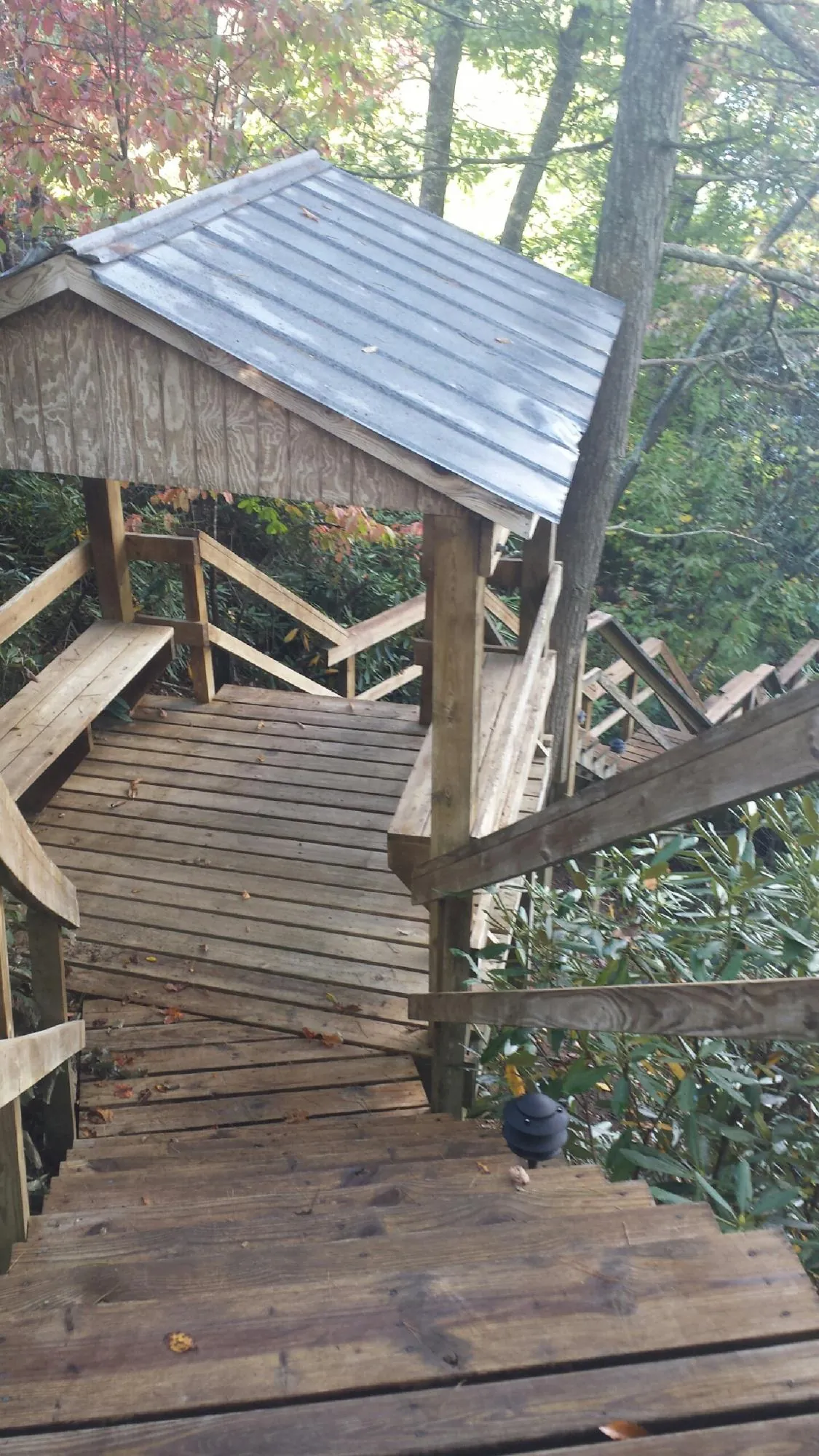 Metal roofed shelter over wooden steps on a wooded walkway — Skylight Repair & Installation work by our crew in Farmington